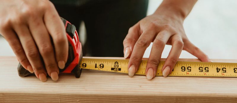 Female carpenter measuring the lumber - Image by © rawpixel
